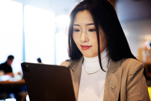 istock Young businesswomen using tablet  at cafe 1365831739