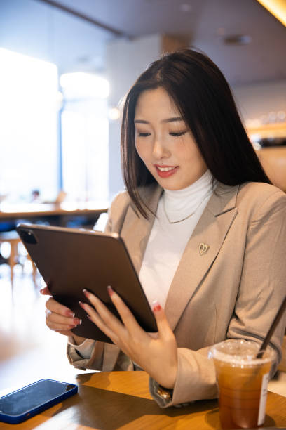 istock Young businesswomen using tablet  at cafe 1365831760