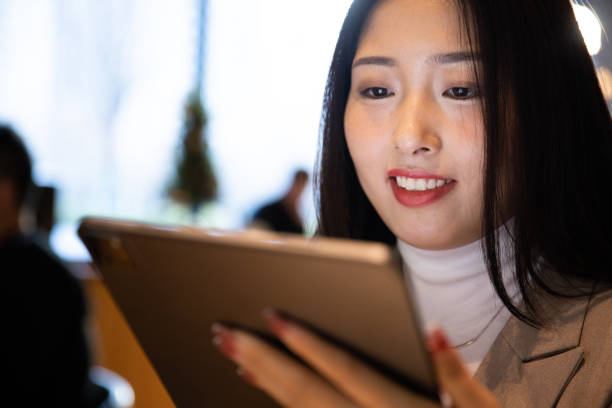 istock Young businesswomen using tablet  at cafe 1365831788