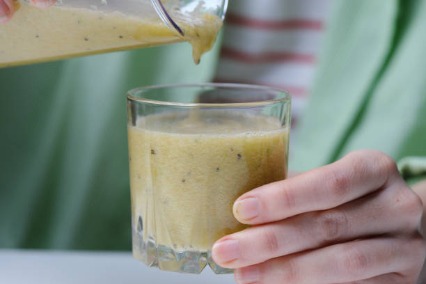 Making detox smoothie with kiwi fruit, green apple, celery and carrot