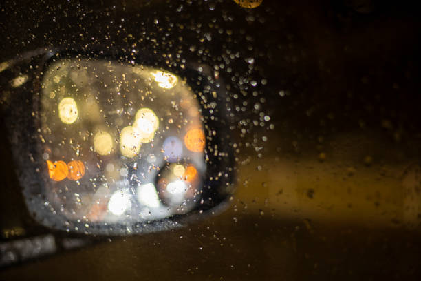 istock abstract blurred background on the right side mirror of a car with bright lights during a traffic jam in the rain 1365838908