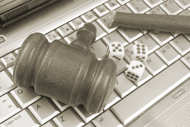 istock Broken wooden judge gavel and dices on computer keyboard. 1365840760
