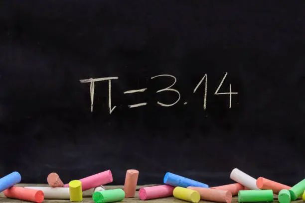 Pi number, mathematical constant chalk drawing on a school black board, Greek letter symbol, 3.14 and colorful chalk piece