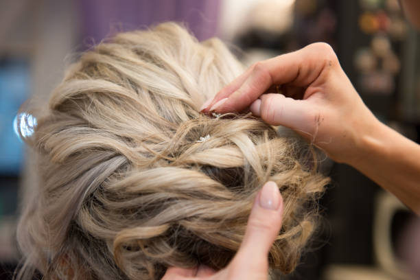 istock Barber's hands are doing a woman's hair. 1365845851