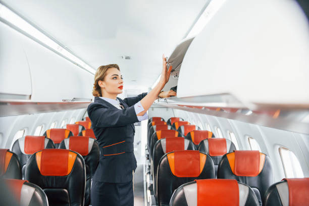 istock Empty seats. Young stewardess on the work in the passanger airplane 1365846492