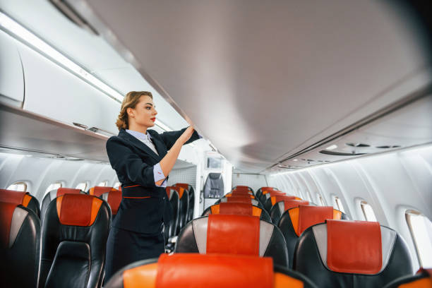 istock Empty seats. Young stewardess on the work in the passanger airplane 1365846498