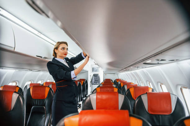 istock Empty seats. Young stewardess on the work in the passanger airplane 1365846502