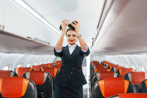 istock Safety instructions. Young stewardess on the work in the passanger airplane 1365846661