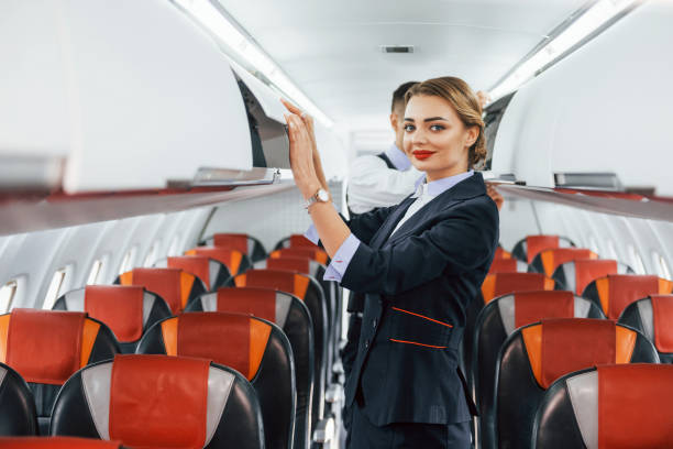 istock Young stewardess with steward on the work in the passanger airplane 1365846795