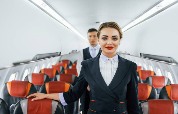 istock Young stewardess with steward on the work in the passanger airplane 1365846807