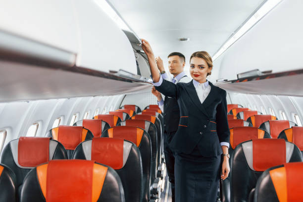 istock Young stewardess with steward on the work in the passanger airplane 1365846811