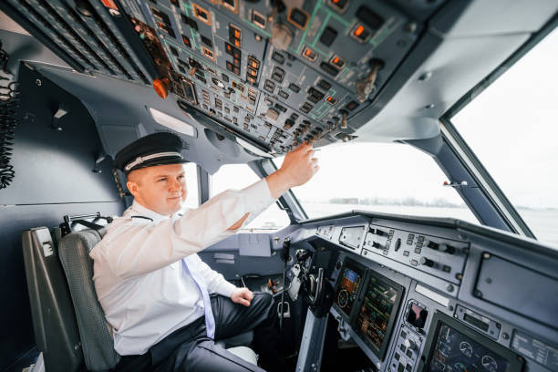 istock Control of the flight. Pilot on the work in the passenger airplane. Preparing for takeoff 1365846849