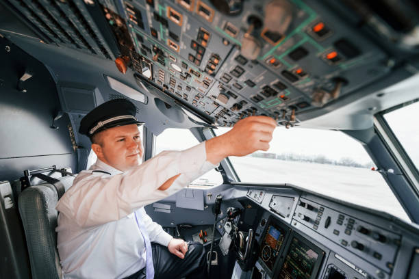 istock Control of the flight. Pilot on the work in the passenger airplane. Preparing for takeoff 1365846871