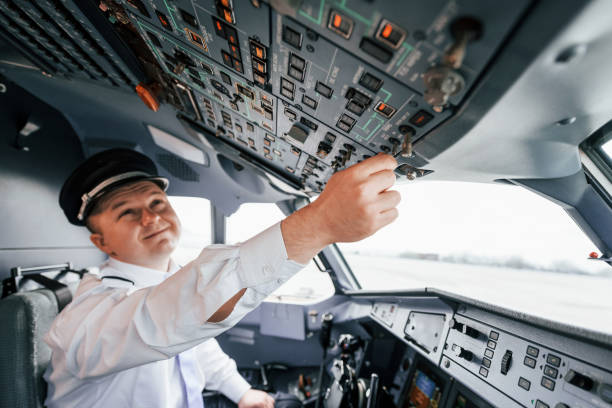 istock Control of the flight. Pilot on the work in the passenger airplane. Preparing for takeoff 1365846900
