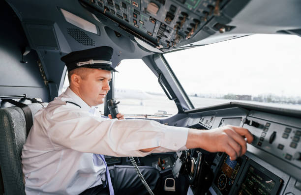 istock Control of the flight. Pilot on the work in the passenger airplane. Preparing for takeoff 1365846923