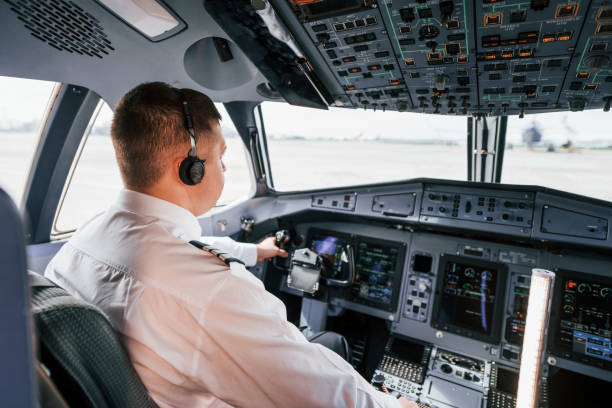 istock Pilot on the work in the passenger airplane. Preparing for takeoff 1365846933