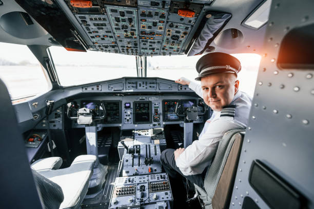 istock Looks behind. Pilot on the work in the passenger airplane. Preparing for takeoff 1365846956