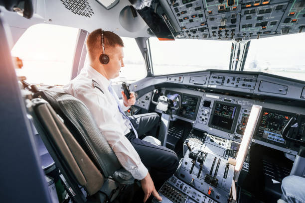 istock Pilot on the work in the passenger airplane. Preparing for takeoff 1365846992