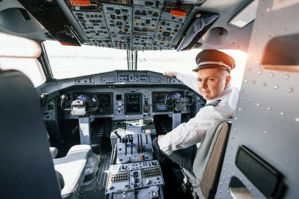 istock Looks behind. Pilot on the work in the passenger airplane. Preparing for takeoff 1365846995