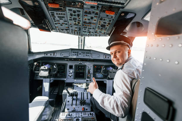 istock Looks behind. Pilot on the work in the passenger airplane. Preparing for takeoff 1365847000