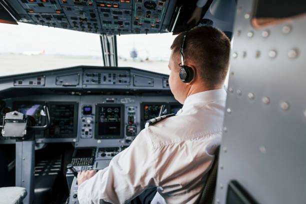 istock Pilot on the work in the passenger airplane. Preparing for takeoff 1365847101