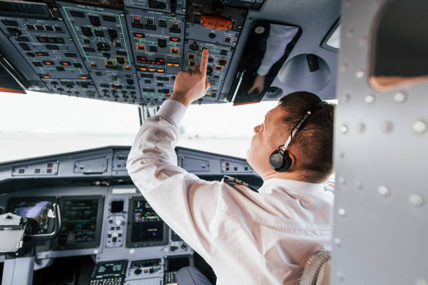 istock Control of the flight. Pilot on the work in the passenger airplane. Preparing for takeoff 1365847103