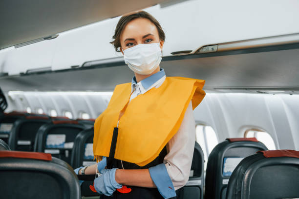 istock Safety instructions. Young stewardess on the work in the passanger airplane 1365848648