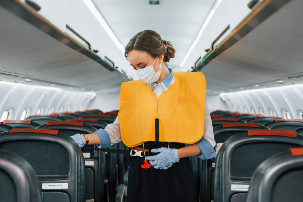 istock Safety instructions. Young stewardess on the work in the passanger airplane 1365848653