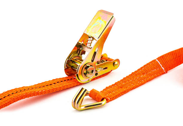 Trailer strop or strap in orange nylon and metal tie isolated over white background. Ratchet straps for cargo load control. Cargo restraint strap stock photo