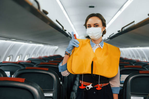 istock Safety instructions. Young stewardess on the work in the passanger airplane 1365848688