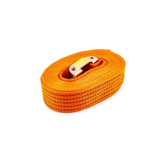 Photo of Trailer strop or strap in orange nylon and metal tie isolated over white background. Ratchet straps for cargo load control. Cargo restraint strap