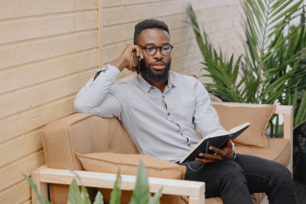 istock African American in an office or coworking talking on the phone and taking notes in a notebook 1365848863