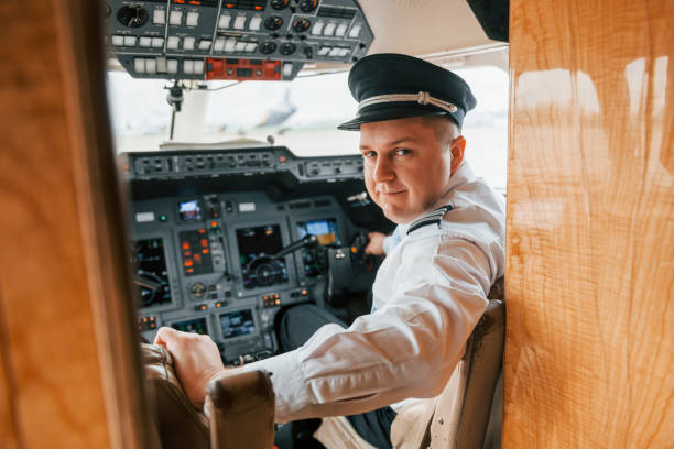 istock Looks behind. Pilot on the work in the passenger airplane. Preparing for takeoff 1365849185