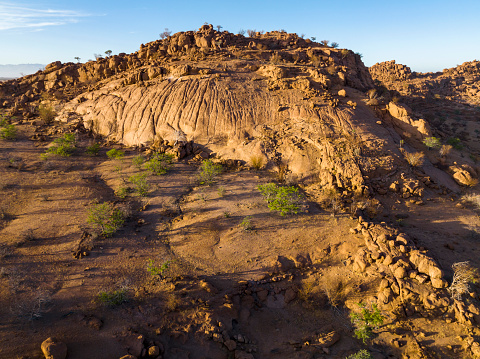 Granite hills with green trees in desert landscape