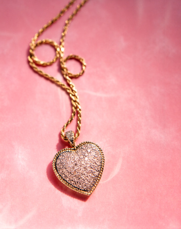 Pave` diamonds fill this heart pendant cluster.
