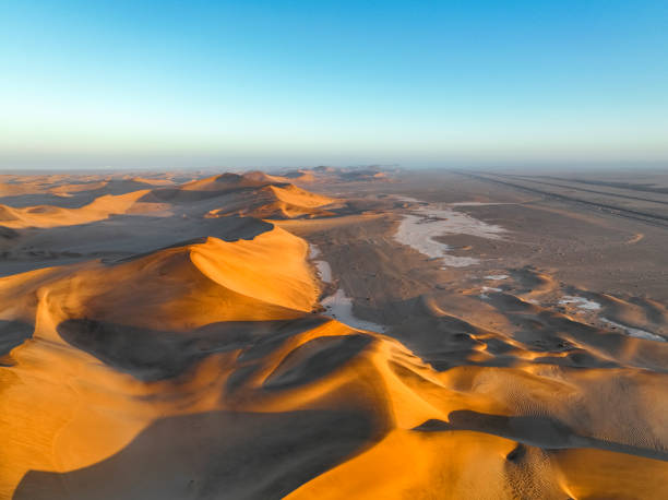 istock Road runs along edge of giant desert dunes 1365849984