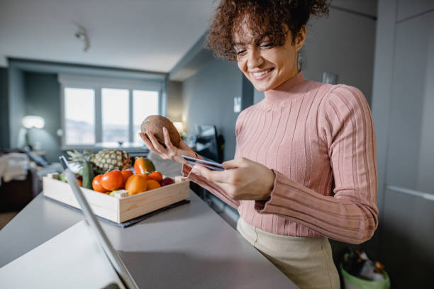 istock Young woman ordering groceries online 1365850688