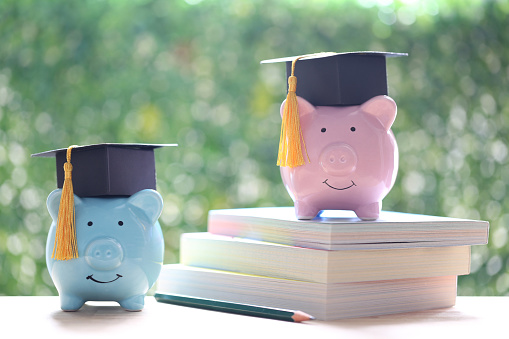 Graduation hat on piggy bank with on nature green background, Saving money for education concept