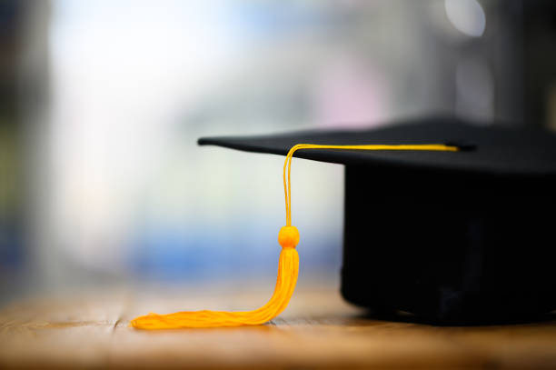 istock Black Graduation Hat placed on wooden board 1365852282