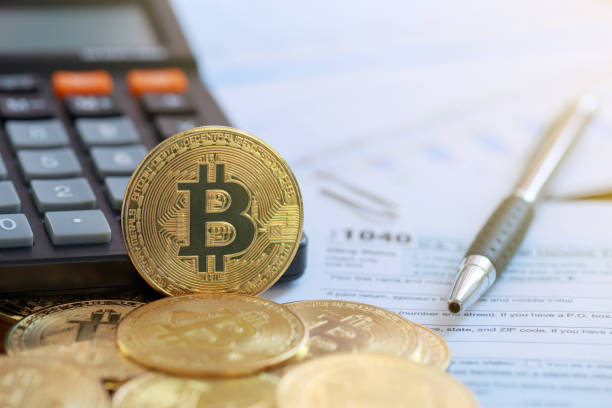 bitcoin on a calculator and individual income tax return form 1040. tax for the trading of crypto-currencies.the time to pay taxes concept. - time and money imagens e fotografias de stock