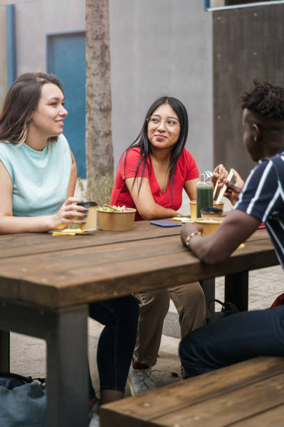 istock Young friends eating take out food and working together during work break 1365854883