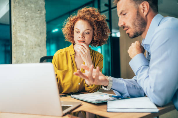 istock Two business people working together in office 1365855640