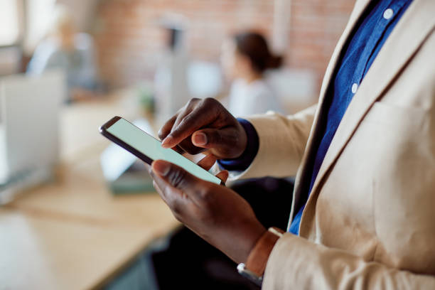 istock Close-up of black entrepreneur using smart phone in the office. 1365855690