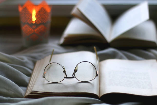 istock Open Books, Reading Glasses and Lit Candle 1365857127