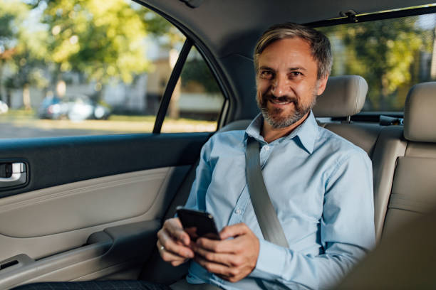 istock Businessman working in a back seat of car. 1365863420
