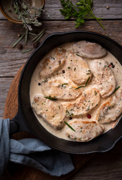 istock Cooked chicken breast with creamy sauce in frying pan 1365864876