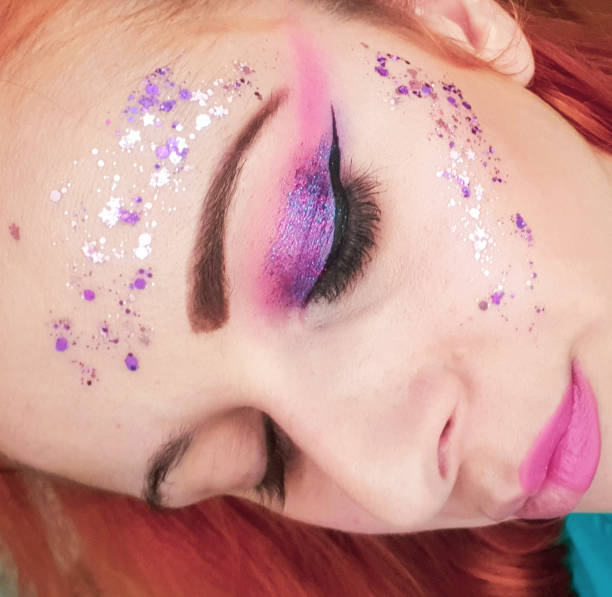 istock Colorful creative purple and shiny make up on my face 1365868293
