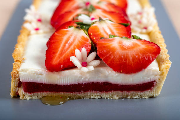 Cake with panna cotta cream and strawberries, decorated with mint and white marzipan flower. Ready to eat.