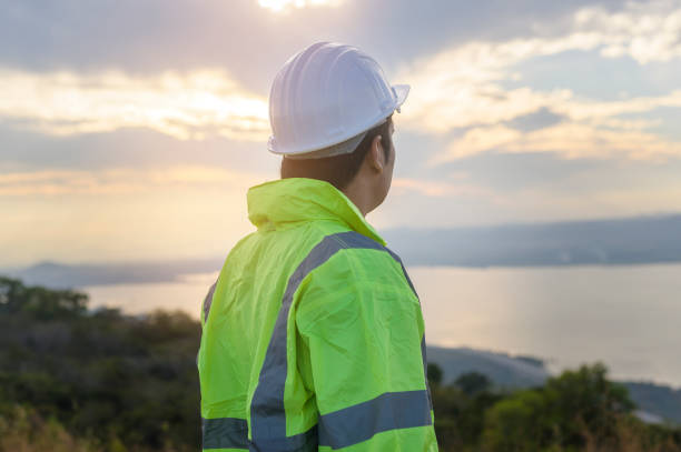 istock a man engineer is putting a protective helmet on her head at sunset. 1365869909