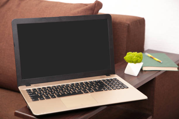 istock Work from home concept: laptop computer with blank white screen on gray sofa bed 1365874628